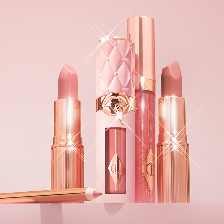 A collection of pink and gold lip products, including lipsticks, lip gloss, and a lip pencil, with sparkles and a luxurious design.
