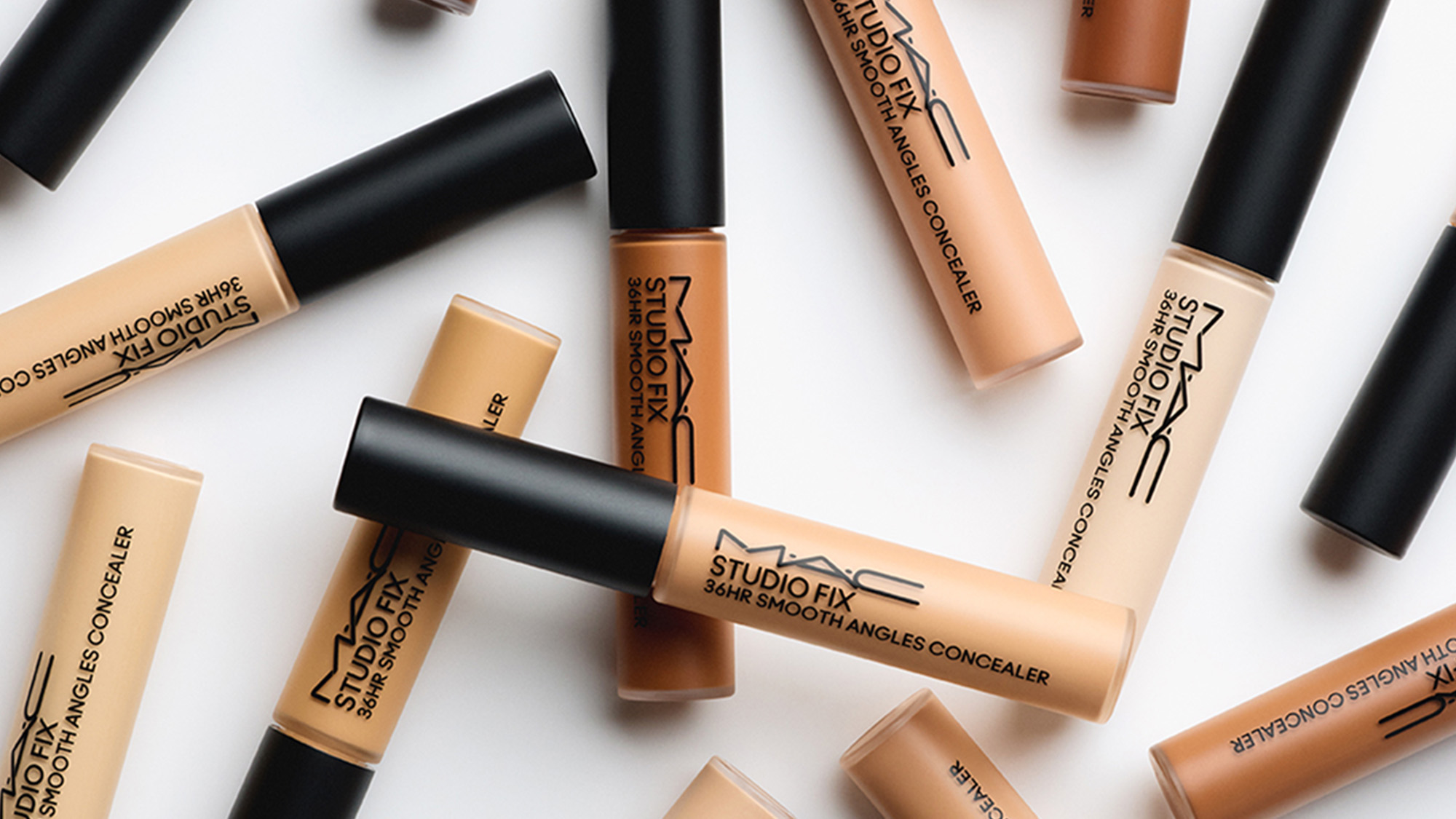 Numerous M.A.C Studio Fix Smooth Angles Concealer tubes are scattered, showcasing different shades.