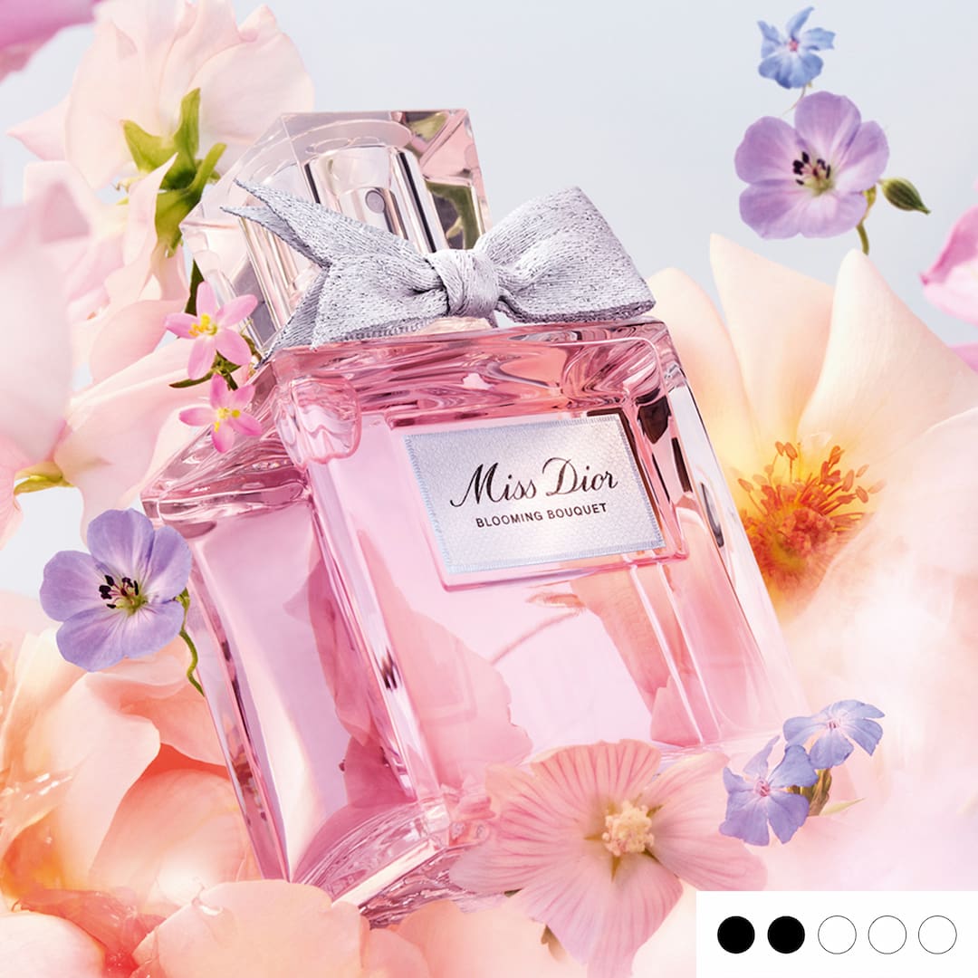 A pink perfume bottle labeled 'Miss Dior Blooming Bouquet' surrounded by pastel flowers.