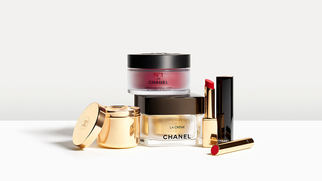 Chanel skincare and makeup products, including creams and lipsticks, displayed on a white surface.