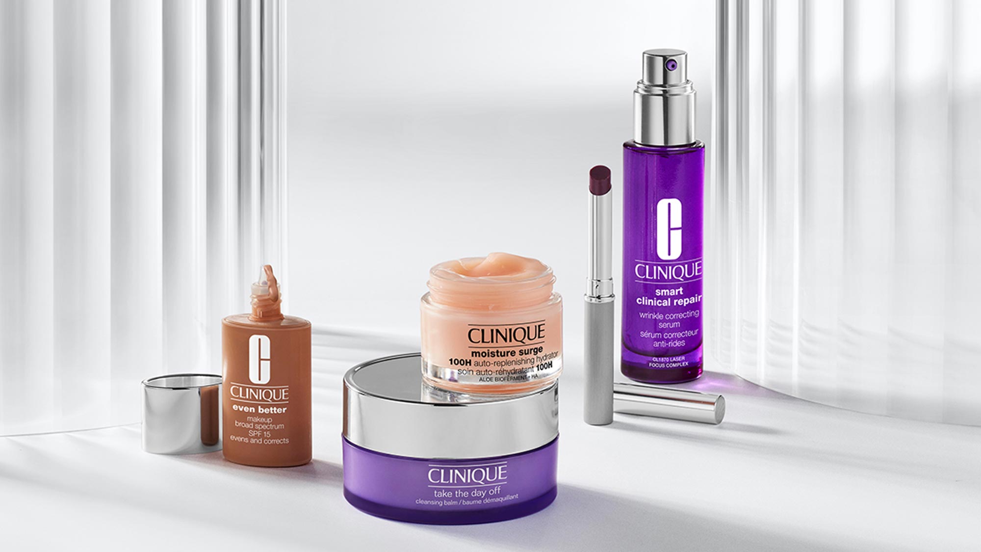 Clinique skincare range including Even Better foundation, Moisture Surge cream, Take The Day Off cleanser, and Smart Clinical Repair serum on white background