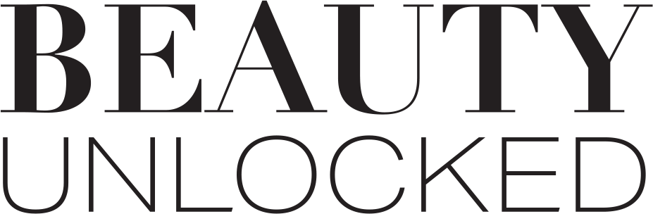 A person in a black outfit, including Spanx leggings, stands against a light wall on a wooden floor.