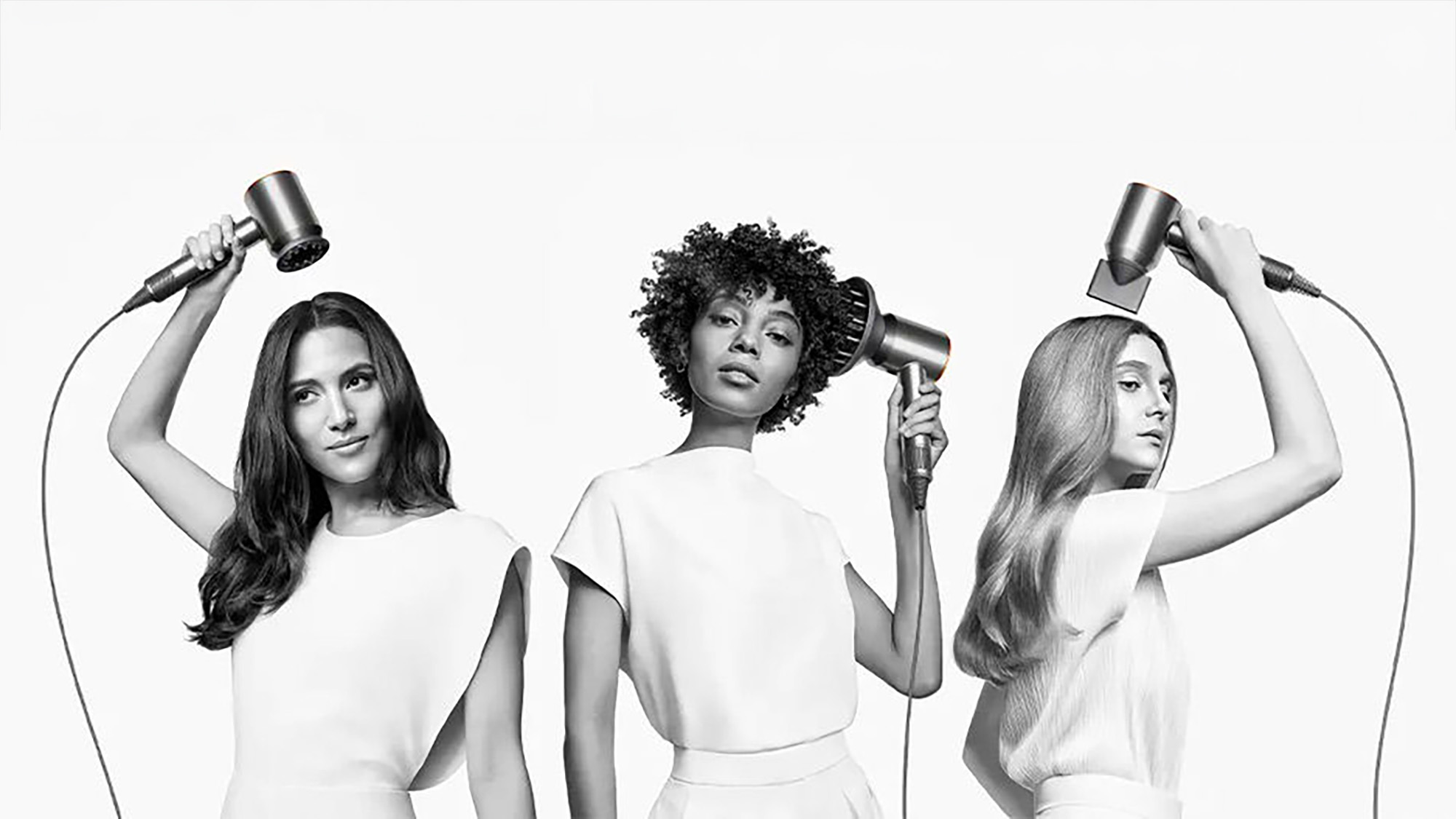 Three women with different hairstyles use hairdryers against a white background.