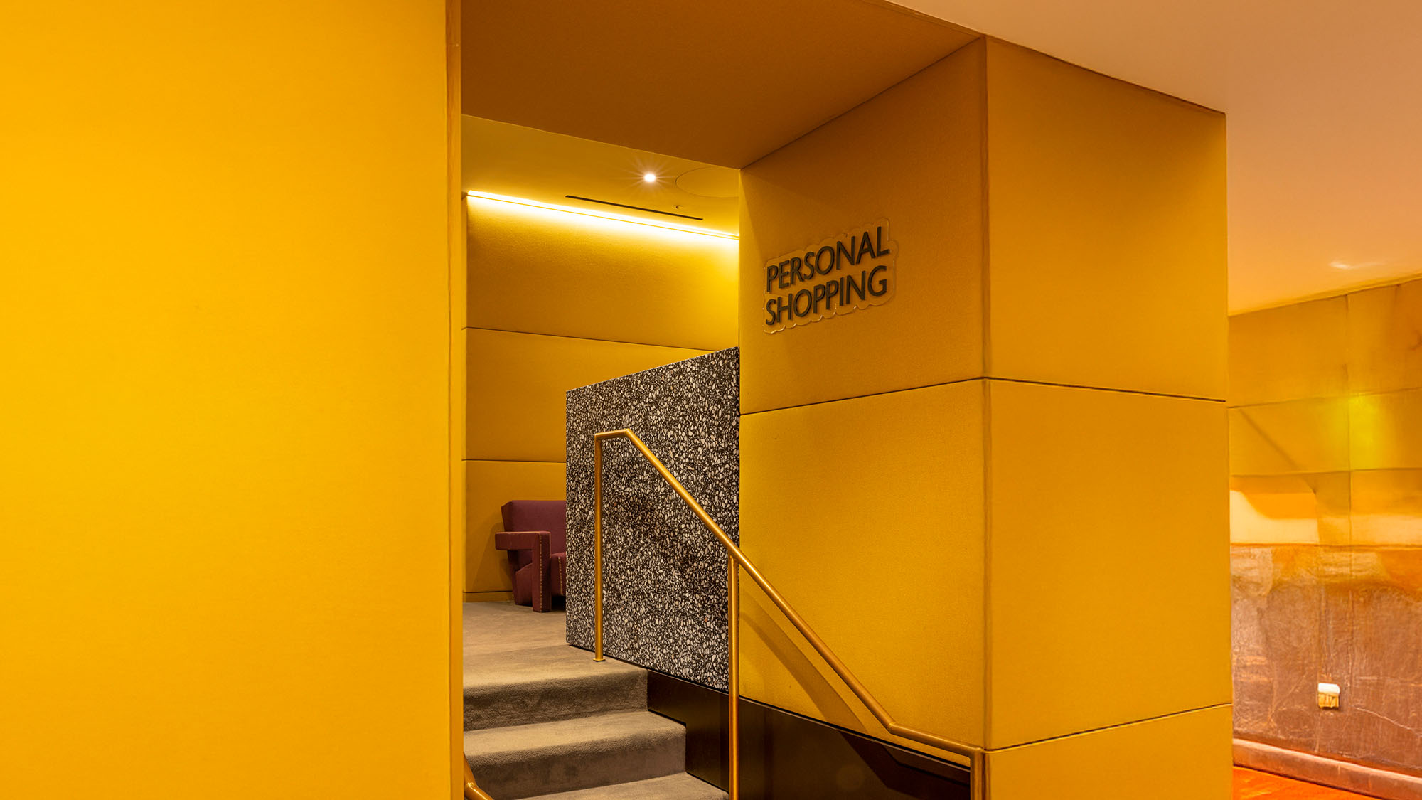 Entrance to a personal shopping area with a yellow and gray interior design.