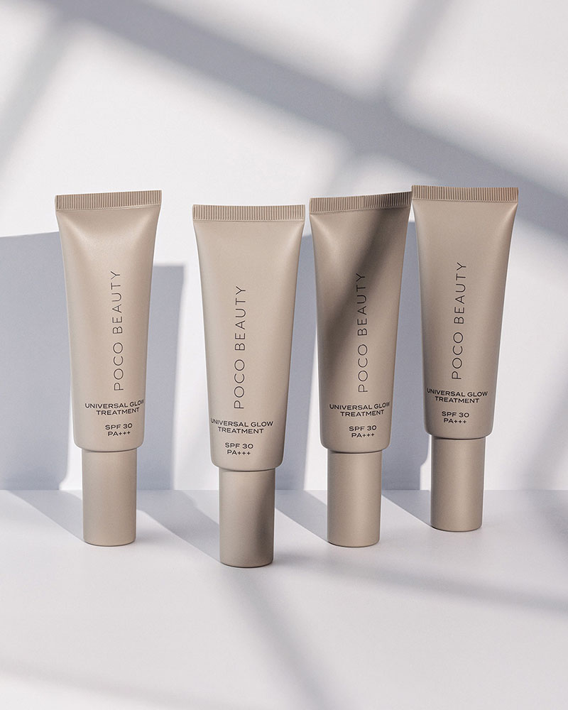 Four beige tubes of POCO Beauty Universal Glow SPF 30 products on a light background with shadows.