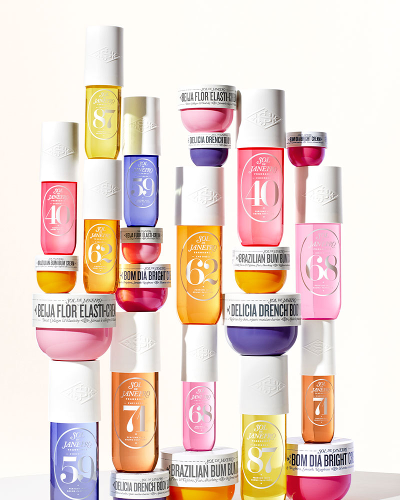 
Assorted colorful skincare products with white lids stacked in rows.


