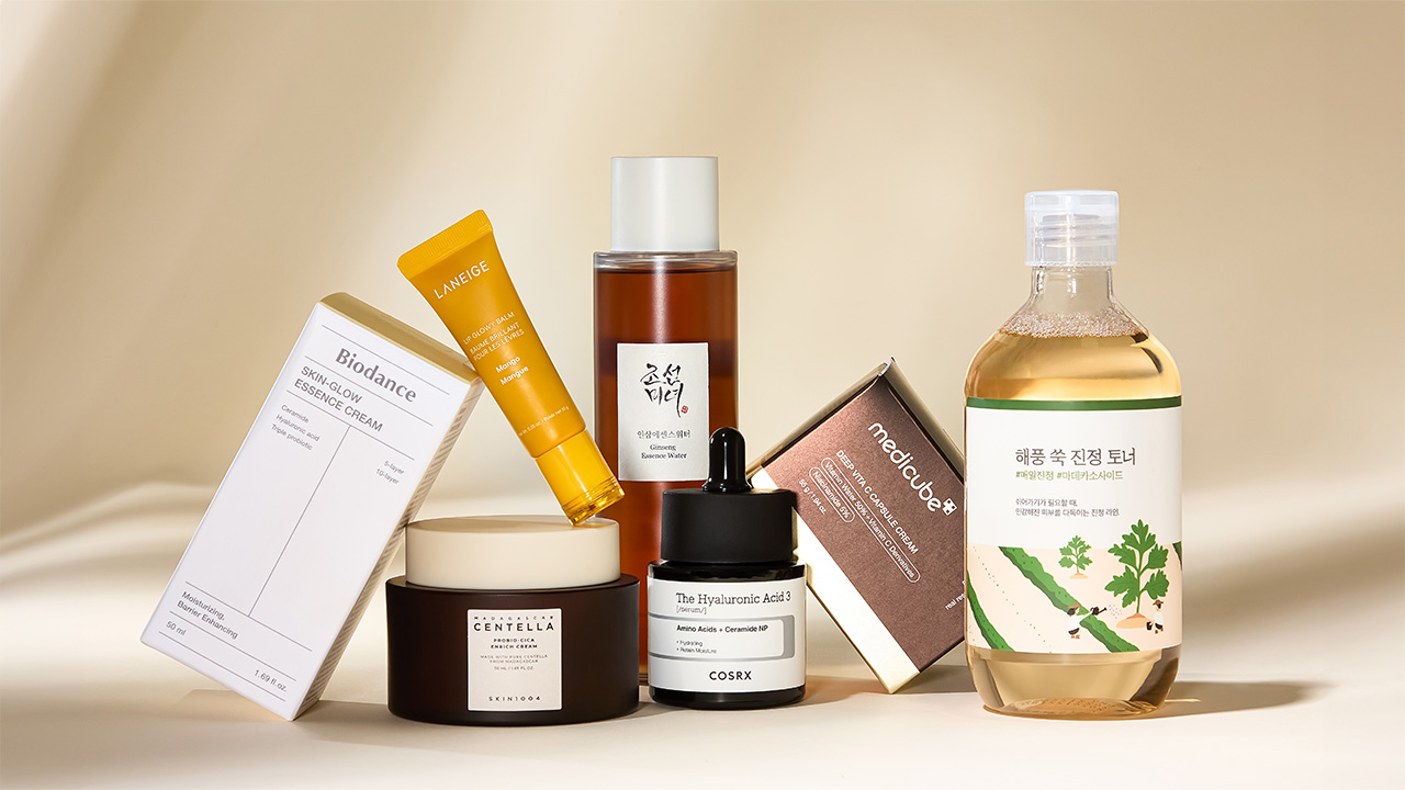 A collection of skincare products including bottles, jars, and boxes arranged on a neutral background.