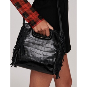 Model carrying Maje Mcroc-Embossed Leather Bag in black with croc texture, fringe sides, and dual top handles, styled with plaid shirt