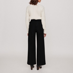 Model wearing Maje Parc Wide Leg Trousers in black, wide-leg silhouette, styled with a cream textured knit sweater. Rear view