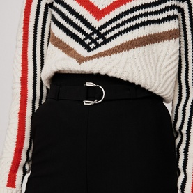 Model wearing Maje Parc Wide Leg Trousers in black with silver-tone D-ring belt, styled with a striped knit top