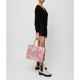 Model wearing Maje Mistral Jewel Button Cardigan in black, styled with shorts and chunky boots, carrying a pink paisley tote bag