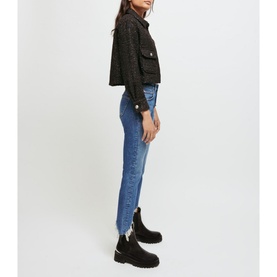 Model wearing Maje Pachabfran Mid-Rise Slim Ripped Hem Jeans in blue denim, styled with a black cropped tweed jacket and black boots