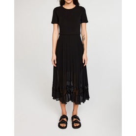 Model wearing Claude Pierlot Teli Pleated Midi Dress in black, short sleeves, sheer pleated skirt, styled with black sandals