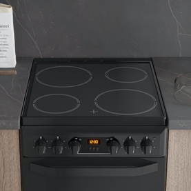 Hotpoint Electric Freestanding Double Cooker in black, with 4-zone ceramic hob, digital display, and black control knobs, set into kitchen worktop
