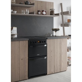 Hotpoint Black Electric Freestanding Double Cooker installed in a modern kitchen with wood cabinetry and dark slate splashback