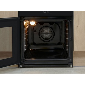 Hotpoint Electric Freestanding Double Cooker in black, interior view showing illuminated oven cavity with rack and fan element