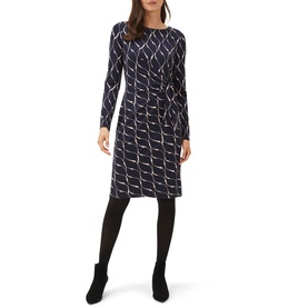 Model wearing Phase Eight Ally Print Dress in blue geometric print, long sleeve, round neck, knee length, with black tights and ankle boots