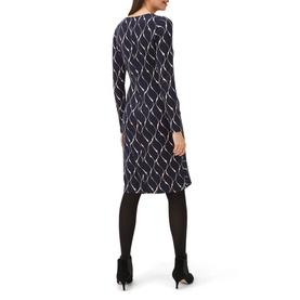 Model wearing Phase Eight Ally Print Dress in blue geometric print, long sleeve, knee length, styled with black tights and heels