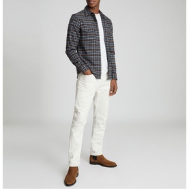 Model wearing Reiss Ash Overshirt in blue check, styled with white t-shirt, cream trousers and tan suede Chelsea boots