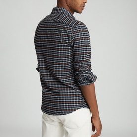 Model wearing Reiss Ash Overshirt in blue check, styled with white trousers, back view with rolled sleeves