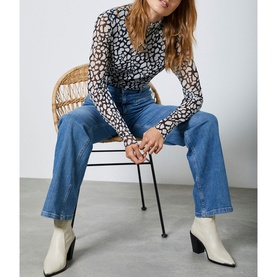 Model wearing Mint Velvet Animal Mesh Polo Neck Top in blue, styled with mid-blue wide-leg jeans and cream ankle boots