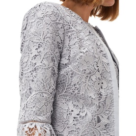 Model wearing Phase Eight Alisha Lace Jacket in green, showing floral lace overlay detail and 3/4 fluted sleeves, crop length, edge to edge design