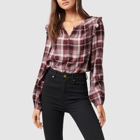 Model wearing Forever New Amy Checked Frill Shoulder Blouse in burgundy plaid with frill shoulders, styled with black high-waisted jeans