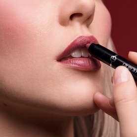 Model with Armani Beauty Color Sketcher lip pencil in Auburn, applied to lips, showing a deep berry-rose finish