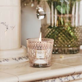 BAOBAB My First Baobab Paris candle in blush pink patterned glass, lit wick, styled on marble surface with greenery in background