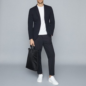 Model wearing Reiss Bless Regular Fit T-Shirt in white with navy blazer and trousers, carrying black tote bag, styled with white trainers