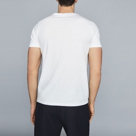 Model wearing Reiss Bless Regular Fit T-Shirt in white, rear view, round neckline and short sleeves, styled with navy trousers