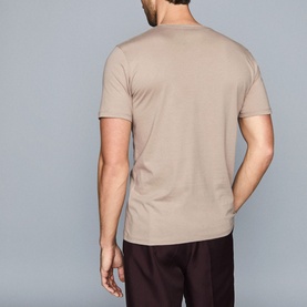 Model wearing Reiss Bless Regular Fit T-Shirt in beige, round neck, short sleeves, rear view, styled with dark trousers