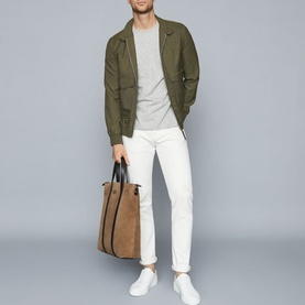 Model wearing Reiss Bless Regular Fit T-Shirt in grey, styled with olive bomber jacket, white trousers and white trainers, carrying tan tote bag