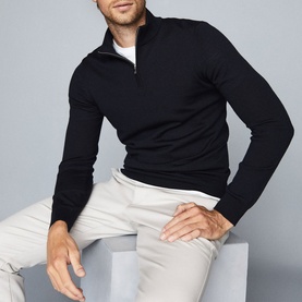 Model wearing Reiss Blackhall Funnel Neck Sweater in blue with a white collar underneath and light grey trousers