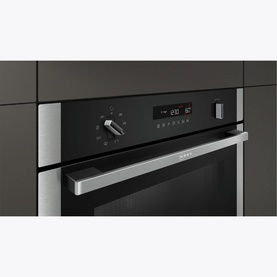 Neff 36 Litre Built-In Combi Microwave with Steam Function in silver, built into dark grey cabinetry, with digital display and control dial