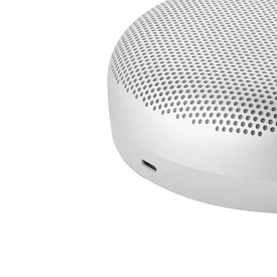 Bang & Olufsen Beosound A1 Gen 2 Grey Mist portable Bluetooth speaker, white compact round design with perforated grille, close-up detail shot