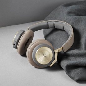 Bang & Olufsen Beoplay H9 Noise-Canceling Wireless Over-Ear Headphones in clay and gold tones, resting on grey surface