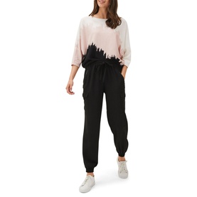 Model wearing Phase Eight Bertie Brushstroke Fine Sweater in pink with black brushstroke design, batwing sleeves, styled with black joggers