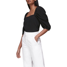 Model wearing Whistles Blanche Square Neck Top in black with puff sleeves, styled with white wide-leg trousers