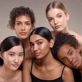 Five models wearing Bobbi Brown Skin Foundation Stick in varied skin tones, showcasing the Cool Honey shade range against a neutral background