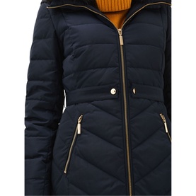 Model wearing Phase Eight Bobbie Short Puffer Coat in blue, showing quilted panels, gold-tone zip detail and snap button at waist