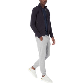 Model wearing Boss Black Casual 55 Tiburt Crew Neck T-Shirt in navy, styled with a dark zip-up jacket and grey joggers, white trainers