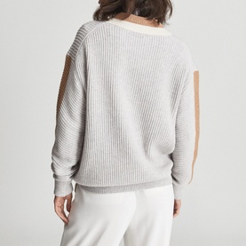 Model wearing Reiss Cora Colour Block Cricket Sweater in grey, showing ribbed knit back with contrast camel panels and cut-out shoulder detail