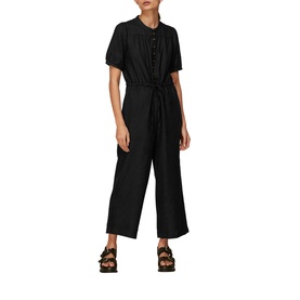 Model wearing Whistles Button Front Linen Jumpsuit in black, short sleeves, tie waist, wide-leg crop, styled with strappy flat sandals