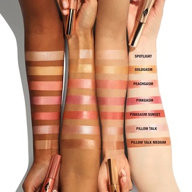 Charlotte Tilbury Hollywood Beauty Light Wand swatches across three skin tones showing Spotlight, Goldgasm, Peachgasm, Pinkgasm, Pinkgasm Sunset,