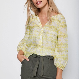 Model wearing Mint Velvet Callie Floral Print Blouse in yellow, styled with khaki tie-waist shorts