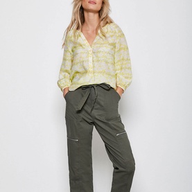Model wearing Mint Velvet Callie Floral Print Blouse in yellow, styled with khaki cargo trousers with zip details and tie waist