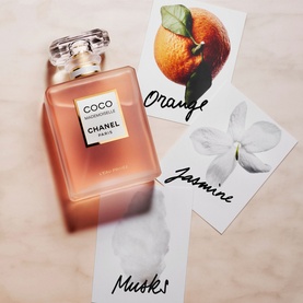 Chanel Coco Mademoiselle L'Eau Priv&eacute;e Night Fragrance bottle beside botanical cards showing orange, jasmine and musk notes