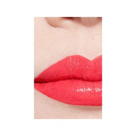 Close-up of lips wearing CHANEL Ultrawear Shine Liquid Lip Colour in a vivid coral-red glossy finish