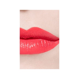 Close-up of lips wearing CHANEL Ultrawear Shine Liquid Lip Colour in a vivid coral-red shade with a glossy finish